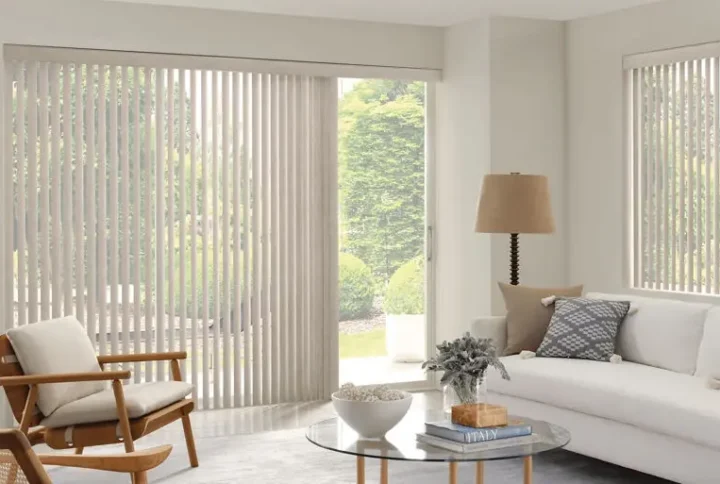 Light-colored Custom Vertical Blinds covering a sliding glass door and a window in a living room.