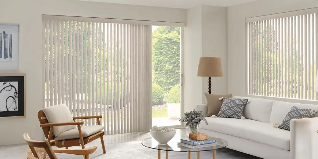 Light-colored Custom Vertical Blinds covering a sliding glass door and a window in a living room.